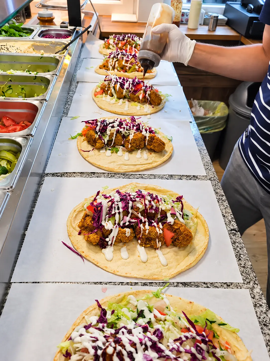 Falafel-Wraps werden an der Theke frisch zusammengestellt
